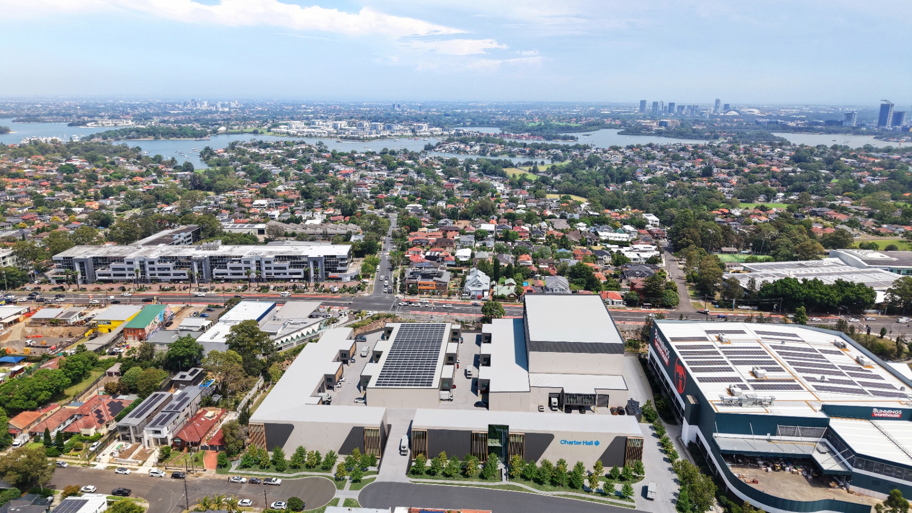 Aerial rendering of the Charter Hall Gladesville development with Bunnings adjacent and Sydney CBD in the distance