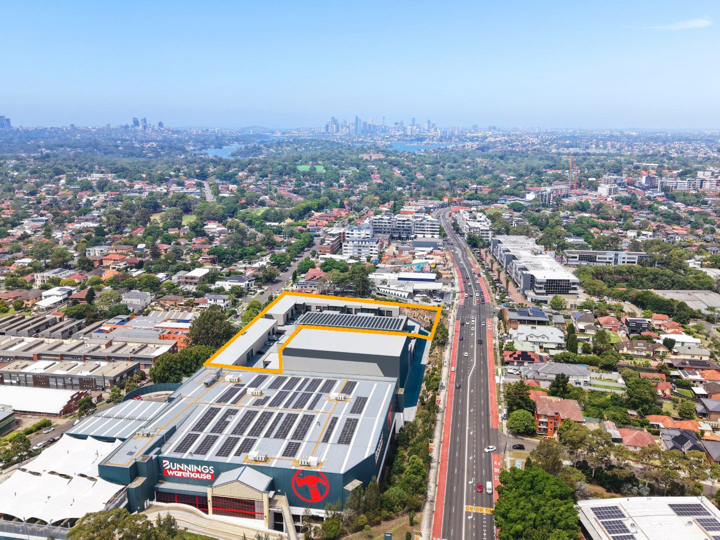 Aerial view of industrial units for sale at 22 College Street, Gladesville with Victoria Road and Sydney CBD beyond